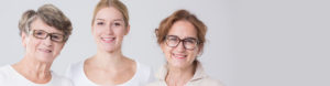 Three women of varying ages smiling against a light gray background at Med Spa Lincoln NE, representing a multi-generational family or group.