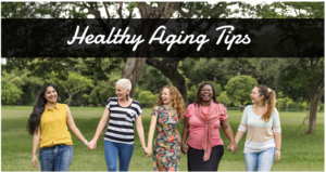 Five diverse women of various ages and ethnicities smiling and holding hands while walking in a park, with the text "healthy aging tips" at the top.