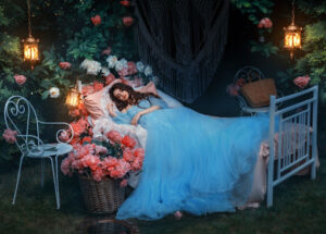 Sleeping woman in gown on open-frame bed covered in flowers.